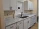 Clean kitchen featuring white cabinets, double sink, and granite countertops at 6638 Hatcher Rd, Lakeland, FL 33811