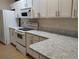 Modern kitchen with white cabinets, granite countertops, and stainless steel appliances at 6638 Hatcher Rd, Lakeland, FL 33811