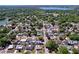 Expansive aerial view of a neighborhood with lush greenery, scattered homes, and a serene lake in the background at 1803 Fredricksburg Ave, Lakeland, FL 33803