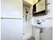 Bathroom featuring a shower, pedestal sink, and dark wood shelving unit at 1803 Fredricksburg Ave, Lakeland, FL 33803