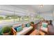 Inviting sunroom with comfortable seating, natural light, and views of the landscaped front yard at 450 Avenue B Ne, Winter Haven, FL 33881