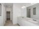 Bright bathroom with double vanity, white cabinets, large mirror and a tiled shower at 6826 Sw 90Th Loop, Ocala, FL 34476