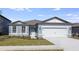 Gray house with two-car garage and landscaped lawn at 6826 Sw 90Th Loop, Ocala, FL 34476
