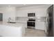 Well-lit kitchen with stainless steel appliances, white cabinets and a stylish backsplash at 6826 Sw 90Th Loop, Ocala, FL 34476