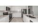 Beautiful kitchen featuring stainless steel appliances, white cabinets and large island with sink at 6826 Sw 90Th Loop, Ocala, FL 34476