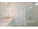 Bright bathroom featuring double sinks with granite countertops and a glass-enclosed shower at 6837 Sw 90Th Loop, Ocala, FL 34476
