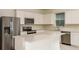 Well-appointed kitchen boasts stainless steel appliances, white cabinets, and a large center island at 6837 Sw 90Th Loop, Ocala, FL 34476