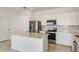Modern kitchen featuring stainless steel appliances, white cabinets, and a spacious center island at 6837 Sw 90Th Loop, Ocala, FL 34476