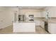 Bright, spacious kitchen featuring stainless steel appliances, white cabinets, and a large center island at 6837 Sw 90Th Loop, Ocala, FL 34476