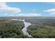 Stunning aerial view of the property featuring lush green trees and a beautiful river under a blue, cloudy sky at 3603 Cr 626N, Bushnell, FL 33513