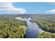 Aerial view showcasing a winding river surrounded by dense, green forests under a blue sky at 3603 Cr 626N, Bushnell, FL 33513