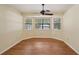 Cozy bedroom illuminated by natural light from three large windows, complemented by stylish wood flooring at 3603 Cr 626N, Bushnell, FL 33513