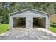 Two-car metal garage, with a large concrete driveway, provides ample space for parking and storage at 3603 Cr 626N, Bushnell, FL 33513