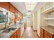 Galley kitchen with wood cabinets, stainless steel sink, gas range, and ample counter space with an adjacent doorway at 3603 Cr 626N, Bushnell, FL 33513