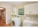 Bright laundry room with white cabinets, stacked washer and dryer, and a window bringing in natural light at 3603 Cr 626N, Bushnell, FL 33513