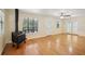 Bright living room with hardwood floors, vintage wood burning stove, and views of the wooded outdoors at 3603 Cr 626N, Bushnell, FL 33513