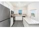 Bright kitchen featuring stainless steel appliances, white cabinets, granite countertops, and grey wood-style floors at 890 Poppy Ln, Dundee, FL 33838