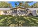 Rear exterior showcasing an enclosed patio space and green backyard under mature shade trees at 8872 Sw 92Nd Pl # E, Ocala, FL 34481