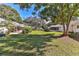 Well-maintained backyard featuring lush green grass and mature trees, with patio and sunroom additions to adjacent homes at 8872 Sw 92Nd Pl # E, Ocala, FL 34481