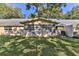 Rear exterior showcasing an enclosed patio space and green backyard under mature shade trees at 8872 Sw 92Nd Pl # E, Ocala, FL 34481