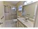 A well-lit bathroom features a shower with sliding glass doors, a standard toilet, and a single sink vanity with mirror at 8872 Sw 92Nd Pl # E, Ocala, FL 34481
