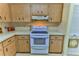 White stove and wood cabinets in this bright kitchen at 8872 Sw 92Nd Pl # E, Ocala, FL 34481