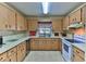 Traditional kitchen featuring tile floors, lots of wood cabinets, stainless steel dishwasher, and white stove at 8872 Sw 92Nd Pl # E, Ocala, FL 34481