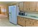 Bright kitchen features wood cabinets, lots of counterspace and a large refrigerator at 8872 Sw 92Nd Pl # E, Ocala, FL 34481