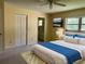Staged main bedroom features carpet, ceiling fan, closet, and bathroom access at 8872 Sw 92Nd Pl # E, Ocala, FL 34481