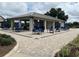 Outdoor pavilion features dining tables, chairs, umbrellas, and landscaped surroundings, creating an inviting space for gatherings at 8872 Sw 92Nd Pl # E, Ocala, FL 34481