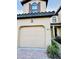 Inviting two story townhome with a tan stucco exterior, decorative shutters, and a two car garage at 8157 Roseville Blvd, Davenport, FL 33896