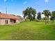 Large backyard with grass, a patio, and a home with a red awning at 431 Bay Leaf Dr, Kissimmee, FL 34759