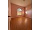 Bedroom with pink walls, wood-look floors, and arched window at 431 Bay Leaf Dr, Kissimmee, FL 34759