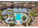 A scenic aerial view featuring the community pool and a tranquil lake with a fountain centerpiece at 8311 Foster Dr, Davenport, FL 33896