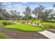 Well-maintained community putting green area, surrounded by lush landscaping and mature trees at 8311 Foster Dr, Davenport, FL 33896