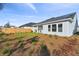 Landscaped backyard with pine straw, grass, and a view of the home's back elevation at 3068 Bootlace Way, St Cloud, FL 34771