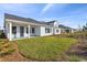 Spacious backyard with grassy lawn, landscaping, and a view of the home's back at 3068 Bootlace Way, St Cloud, FL 34771