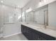 Elegant bathroom with double vanity, large mirror, and walk-in shower at 3068 Bootlace Way, St Cloud, FL 34771