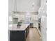 Modern kitchen with white cabinets, quartz countertops, and a dark island at 3068 Bootlace Way, St Cloud, FL 34771