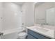 Modern bathroom with white tile, shower and a sleek blue vanity with white countertop at 3051 Bootlace Way, St Cloud, FL 34771