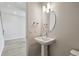 This bathroom features a pedestal sink, oval mirror, and modern lighting at 3051 Bootlace Way, St Cloud, FL 34771