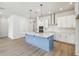 Bright kitchen with a quartz island, stainless steel appliances, and minimalist pendant lights at 3051 Bootlace Way, St Cloud, FL 34771