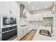 Well-lit kitchen features white cabinets, stainless steel appliances, and quartz countertops at 3051 Bootlace Way, St Cloud, FL 34771