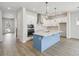 Stylish kitchen showcasing white cabinets, a blue island, stainless appliances, and an open layout at 3051 Bootlace Way, St Cloud, FL 34771