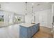 Modern kitchen with stainless steel appliances, pendant lights, and blue island at 3051 Bootlace Way, St Cloud, FL 34771