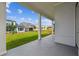 A covered patio offers an outdoor living space overlooking the green lawn and neighborhood at 3051 Bootlace Way, St Cloud, FL 34771