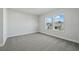 A bright bedroom featuring carpet floors, two windows, and views of the neighborhood at 3062 Bootlace Way, St Cloud, FL 34771