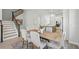 Light-filled dining area with table, upholstered chairs, and access to kitchen and staircase at 3062 Bootlace Way, St Cloud, FL 34771