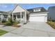 Inviting single-story home featuring a covered porch with seating and an attached two-car garage at 3062 Bootlace Way, St Cloud, FL 34771