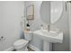 This powder room features a pedestal sink, a round mirror, and a stylish faucet at 3062 Bootlace Way, St Cloud, FL 34771